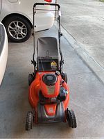 Front view of mower with handle upright and attached grass catcher