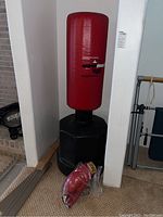 Full view of Wave Master red portable training punching bag with black water-filled base and packaged red boxing gloves at the bottom.