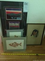 Overview photo showing all four artworks together, including landscape painting, portrait, and two salmon prints in glass frames.