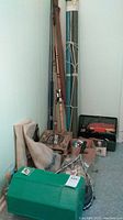 Full lot arranged indoors showing rods, green tackle box, net, and bags.