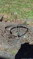 Full view of brass sundial placed on stone surface with grass background