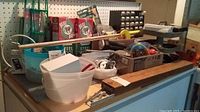 Photo of bench area with various hardware items, hand tools, and packaging boxes