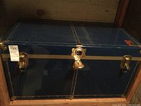 Front view of large vintage blue trunk showing lock and latch clasps