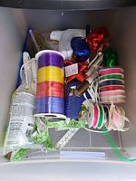 Close-up of ribbons, tapes, measuring tapes, and small tools in drawer