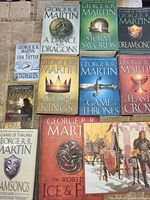 Photo of 8 George R R Martin hardcover books in the A Song of Ice and Fire series with visible cover art.