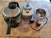 Photo of the Cuisinart waffle maker and food processor with attachments on a tiled surface.