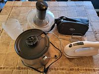 Juicer parts, hand mixer with beaters and carrying bag arranged on tiled surface