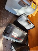 Plastic tool carrying cases stacked with Ryobi and Porter Cable branding visible.
