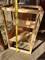 Wooden frame of the stand showing height measurement tape indicating approximately 40 inches tall; visible paint marks and used condition of wood.