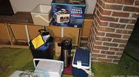 Full view of lot showing coolers, lunch bag, thermos, and boxed travel cooler/warmer.