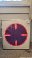 Full front view of framed silkscreen print leaning against wall