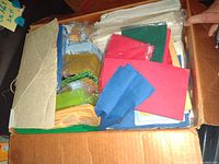 Box filled with assorted disposable napkins of various colors including red, blue, green, yellow