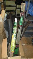 Full and partial rolls of black landscape fabric standing vertically in a box.