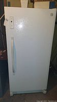Full view of the white standing freezer with vertical door handle.