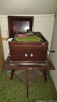 Full view of antique Victrola phonograph on wooden stand.