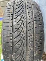Close view of the tire tread showing directional pattern and moderate wear.