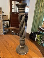 Front view of the large wooden candlestick showing the twisted central column design, round base, and top candle holder.
