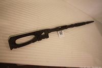 Full length view of the carved wooden African walking stick showing the entire stick horizontally on a white background.