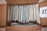 Top view of box filled with hundreds of postcards packed vertically.
