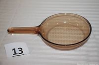 Top view of amber glass saute pan showing clear and smooth glass with handle