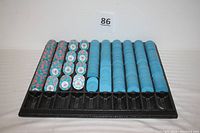 Tray holding all poker chips, organized in columns: mostly blue chips, some multicolored chips.