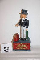 Full front view of the Uncle Sam mechanical penny bank showing figure, base with eagle and satchel bag.