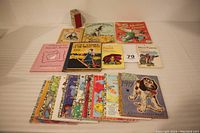 Full set of sixteen vintage children's books arranged on white surface showing various titles and colorful covers.