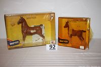 Two Breyer horse models in original yellow boxes shown side by side, taped and aged boxes visible.