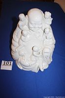 Photo showing the full statue of the seated Buddha with five children arranged on and around the figure.