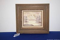 Framed winter scene oil painting with visible seller tag '102'.