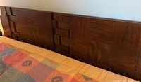 Close-up of wood headboard showing geometric block design