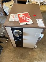 Front and top view of the Fire-Fyter safe showing combination lock, handle, and condition with signs of use and dust.