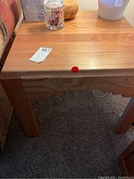 Side view of one table next to sofa with decorative items on top and maxsold tag visible