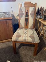 Front view of one dining chair showing full wooden frame and fabric seat and back cushions with Southwestern geometric pattern upholstery.