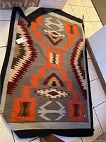 Full view of flat weave rug showing overall geometric pattern and border