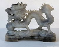 Front and side view of the hand carved stone dragon showing detailed carving and base