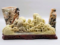 Front view of the Asian stone carving group showing the carved landscape and two vases