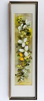 Full view of the framed vertical watercolor painting showing white, yellow, and orange flowers against a green background.