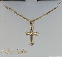 Gold cross pendant on twisted rope gold-filled chain displayed in white jewelry box with '10K Gold' inscription.