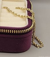 Bracelet draped inside open purple velvet box showing chain detail and box interior