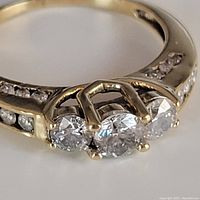 Front view of ring showing three-diamond cluster and channel-set side stones