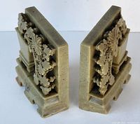 Front and side angle view of both marble bookends showing the carved floral pattern and shape.