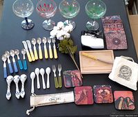 Set of margarita glasses, flatware, spoons, coasters, mini boards and accessories on black surface