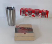 Full view of Yeti tumbler, boxed Chinese zodiac rubber stamps, and Feng Shui shot glass set in red packaging with four glasses visible.