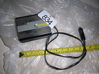 Xantrex Power 300 inverter showing front side with cigarette lighter plug cable and measuring tape for scale.