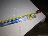 Photo showing closet rod in original packaging with measuring tape indicating approximately 55 inches length.