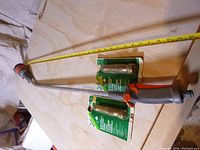 Overall view of the two brass hose nozzles in packaging and Gardena wand about 36 inches long with measuring tape.