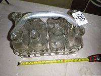 Top-down photo showing all eight clear glass bottles fitted into an aluminum carrying case with handle.