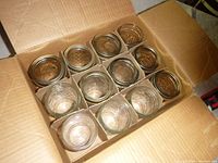 Top view of 12 mason jars in cardboard case showing clear glass jars arranged neatly in compartments.
