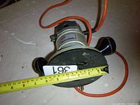 Top view of Black & Decker 7610 router showing body, handles, attached orange power cord, and approximate base diameter of 6.5 inches.
